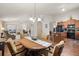 Bright dining room adjacent to kitchen and living room featuring hardwood floors and stylish chandelier at 1889 Raegan Way, Lawrenceville, GA 30043