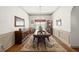 Formal dining room featuring hardwood floors, wainscoting, chandelier, and ample seating at 1889 Raegan Way, Lawrenceville, GA 30043
