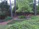 Backyard with lush landscaping including mature bushes, flowers, and trees at 5741 Wolf Laurel Ln, Lilburn, GA 30047