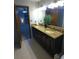 Granite countertop bathroom vanity with double sinks, tile floor, and wood door to bedroom at 5741 Wolf Laurel Ln, Lilburn, GA 30047