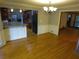 Dining area with bar counter, chandelier, hardwood floors, wainscoting, and access to the kitchen at 5741 Wolf Laurel Ln, Lilburn, GA 30047