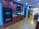 Modern kitchen with granite countertops, black appliances, hardwood floors, colorful backsplash, and ample cabinet space at 5741 Wolf Laurel Ln, Lilburn, GA 30047