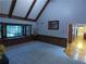 Open living room featuring vaulted ceiling with wood beams, beautiful window seat, and wood paneled wall at 5741 Wolf Laurel Ln, Lilburn, GA 30047