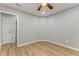 This bedroom features light, airy walls, a ceiling fan and wood-look laminate flooring at 7074 Babbling Brook Dr, Jonesboro, GA 30236