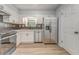Updated kitchen featuring stainless steel appliances, white cabinets, and wood flooring at 7074 Babbling Brook Dr, Jonesboro, GA 30236