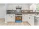 Well-lit kitchen featuring white cabinetry, tiled backsplash, and modern appliances at 7074 Babbling Brook Dr, Jonesboro, GA 30236