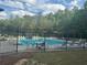 Fenced community pool with chairs, pool furniture and tree line in the background at 955 Tributary Way, Dacula, GA 30019