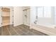 Modern bathroom featuring a glass-enclosed shower, a soaking tub, and sleek gray tile flooring for a spa-like retreat at 1795 Fulmont Cir, Mableton, GA 30126
