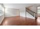 Empty living room features hardwood floors, a staircase, and large windows at 290 Lakemoore Ne Dr # C, Atlanta, GA 30342