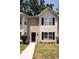 Charming townhome featuring a brick facade, black shutters, and well-maintained landscaping at 5538 Pineridge Ct, Forest Park, GA 30297