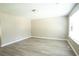 Bright, neutral living room with light wood-look floors and modern lighting fixture at 5538 Pineridge Ct, Forest Park, GA 30297