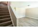 Neutral living room with light wood-look floors and modern lighting fixture near stairs at 5538 Pineridge Ct, Forest Park, GA 30297
