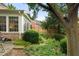 Landscaped backyard with brick patio, lush greenery, mature trees, and a view of the home's exterior and sunroom at 2350 Rosebrook Se Xing, Atlanta, GA 30339