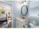 Bright powder room featuring a white vanity with sink, mirror, and an open view to an adjacent bedroom at 2350 Rosebrook Se Xing, Atlanta, GA 30339