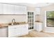 Bright kitchen features granite countertops, stainless steel dishwasher, white cabinets and glass panel door to backyard at 468 Watson Ferry Dr, Forest Park, GA 30297