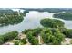 Expansive aerial view of a tranquil lake surrounded by lush green trees and shoreline properties at 6178 Lake Lanier Height Rd, Buford, GA 30518