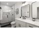 Well-lit bathroom featuring double sinks, marble counters, and glass shower with modern fixtures and design at 6178 Lake Lanier Height Rd, Buford, GA 30518