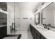 Elegant bathroom featuring double sinks, marble countertops, and a modern glass-enclosed shower with black hardware at 6178 Lake Lanier Height Rd, Buford, GA 30518