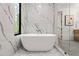 Stylish bathroom with a freestanding tub and marble wall tiles at 6178 Lake Lanier Height Rd, Buford, GA 30518