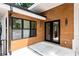 Stylish front porch with wood siding, modern lighting, and black framed windows and glass door at 6178 Lake Lanier Height Rd, Buford, GA 30518