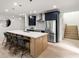 Well-lit kitchen with stainless steel appliances, a center island with barstool seating, and dark cabinets at 6178 Lake Lanier Height Rd, Buford, GA 30518