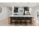 Bright kitchen with a center island with barstool seating, marble countertops, and stainless steel appliances at 6178 Lake Lanier Height Rd, Buford, GA 30518