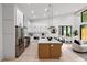 Open-concept kitchen with island seating and stainless steel appliances flows into the dining and living spaces at 6178 Lake Lanier Height Rd, Buford, GA 30518
