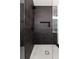 Modern shower featuring dark tile, a built-in niche, and a rainfall showerhead for a spa-like experience at 6178 Lake Lanier Height Rd, Buford, GA 30518