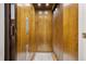 Residential elevator featuring paneled wood walls and carpet, offering an accessible and stylish option for multi-story living at 717 Lenox Ln, Atlanta, GA 30324