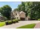 Tan two-story home with three car garage, stone accents, and beautiful landscaping at 820 Chelsea Park Ne Dr, Marietta, GA 30068