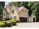 Tan two-story home with three car garage, stone accents, and beautiful landscaping at 820 Chelsea Park Ne Dr, Marietta, GA 30068