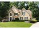 Charming front elevation of tan home with stone accents, black trim, and professionally landscaped yard at 820 Chelsea Park Ne Dr, Marietta, GA 30068
