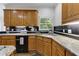 Traditional kitchen with wooden cabinetry, granite countertops, and black tile backsplash at 820 Chelsea Park Ne Dr, Marietta, GA 30068