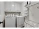 Well-organized laundry room with upper cabinets, shelving, and front load washer and dryer at 820 Chelsea Park Ne Dr, Marietta, GA 30068