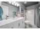Bathroom featuring a white vanity, marble countertop, tub with shower, and calming blue accents at 11352 Musette Cir, Alpharetta, GA 30009