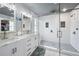 Modern bathroom with a double sink vanity, walk-in shower with glass door and stone flooring at 11352 Musette Cir, Alpharetta, GA 30009