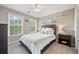 Cozy bedroom with a full-sized bed, bedside table, artwork, and sunlit windows at 11352 Musette Cir, Alpharetta, GA 30009
