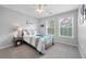 Bright bedroom with a queen-sized bed, nightstand, and natural light from two windows at 11352 Musette Cir, Alpharetta, GA 30009