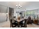 Spacious dining area flowing into a living room with neutral colors, large windows, and fireplace at 11352 Musette Cir, Alpharetta, GA 30009