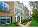 Townhome exterior featuring brick, black shutters, and a well-maintained landscape at 11352 Musette Cir, Alpharetta, GA 30009
