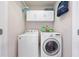 Efficient laundry room with modern washer and dryer, storage cabinets, and ample space for laundry tasks at 11352 Musette Cir, Alpharetta, GA 30009