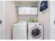 Functional laundry room featuring a front-load washer and dryer, white cabinets, and ample space at 11352 Musette Cir, Alpharetta, GA 30009