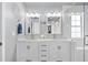 Elegant main bathroom with double sinks, a marble countertop, modern lighting, and tiled shower at 11352 Musette Cir, Alpharetta, GA 30009