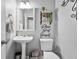Stylishly decorated powder room with pedestal sink, toilet, and decorative wall art at 11352 Musette Cir, Alpharetta, GA 30009