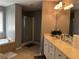 Bright bathroom featuring a large mirror, tub, and walk-in shower with glass doors at 1498 Park Knoll Trl, Lawrenceville, GA 30043