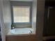 Large bathroom with a tiled jacuzzi tub under window and glass enclosed walk-in shower at 1498 Park Knoll Trl, Lawrenceville, GA 30043