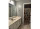 Neutral bathroom features a single sink vanity with ample cabinet storage and a tub/shower combo with a colorful shower curtain at 1498 Park Knoll Trl, Lawrenceville, GA 30043