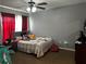 Cozy bedroom featuring plush carpet, ceiling fan and a comfortable bed with red and white curtains at 1498 Park Knoll Trl, Lawrenceville, GA 30043