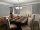 Formal dining room features modern chandelier and stylish hardwood table at 1498 Park Knoll Trl, Lawrenceville, GA 30043