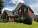 Charming two-story home with lush green lawn, mature trees, and well-maintained landscaping features at 1498 Park Knoll Trl, Lawrenceville, GA 30043